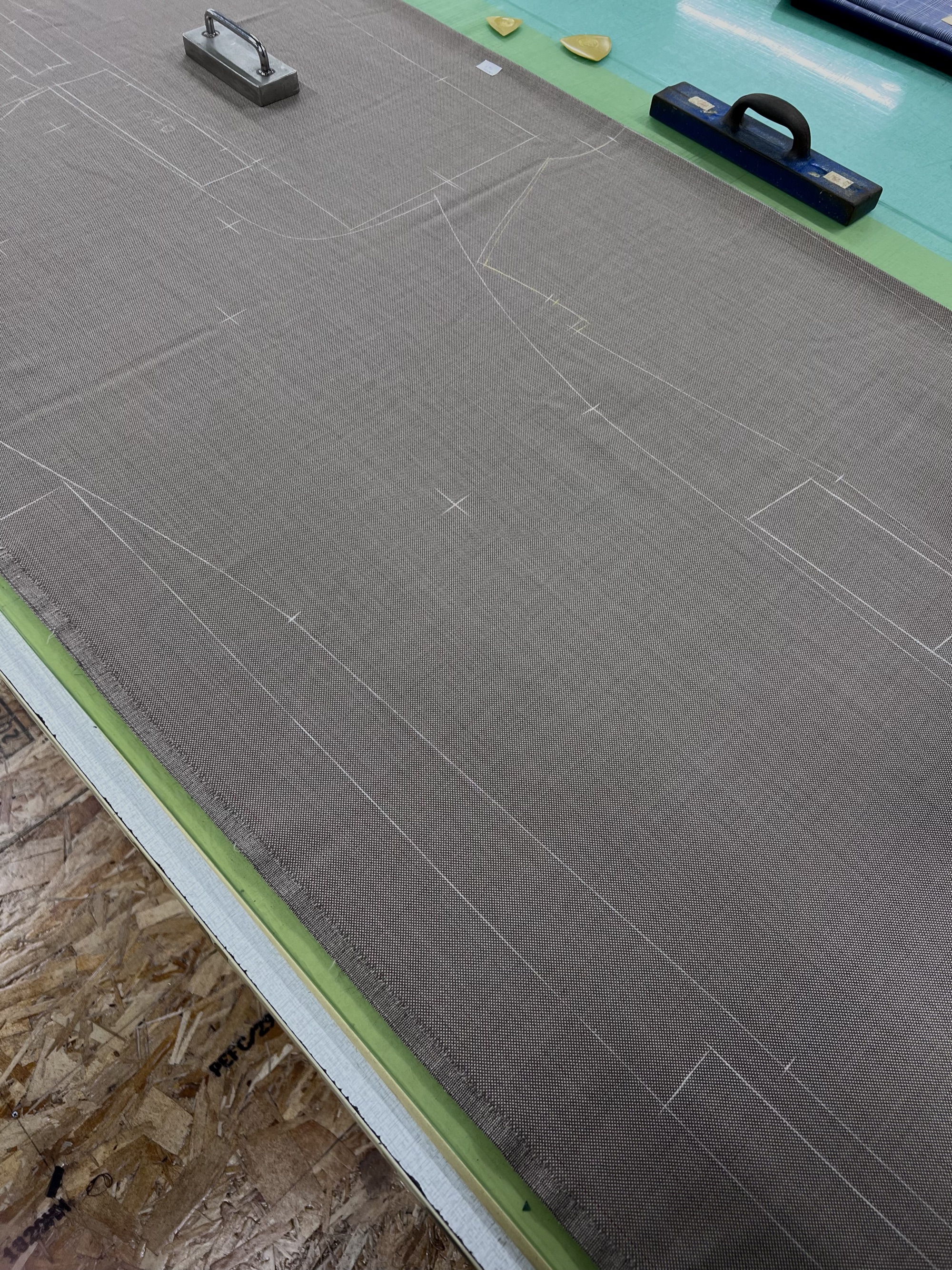 A jacket layout chalked onto cloth, weighted on the cutting table at Five One Factory, Hirakata