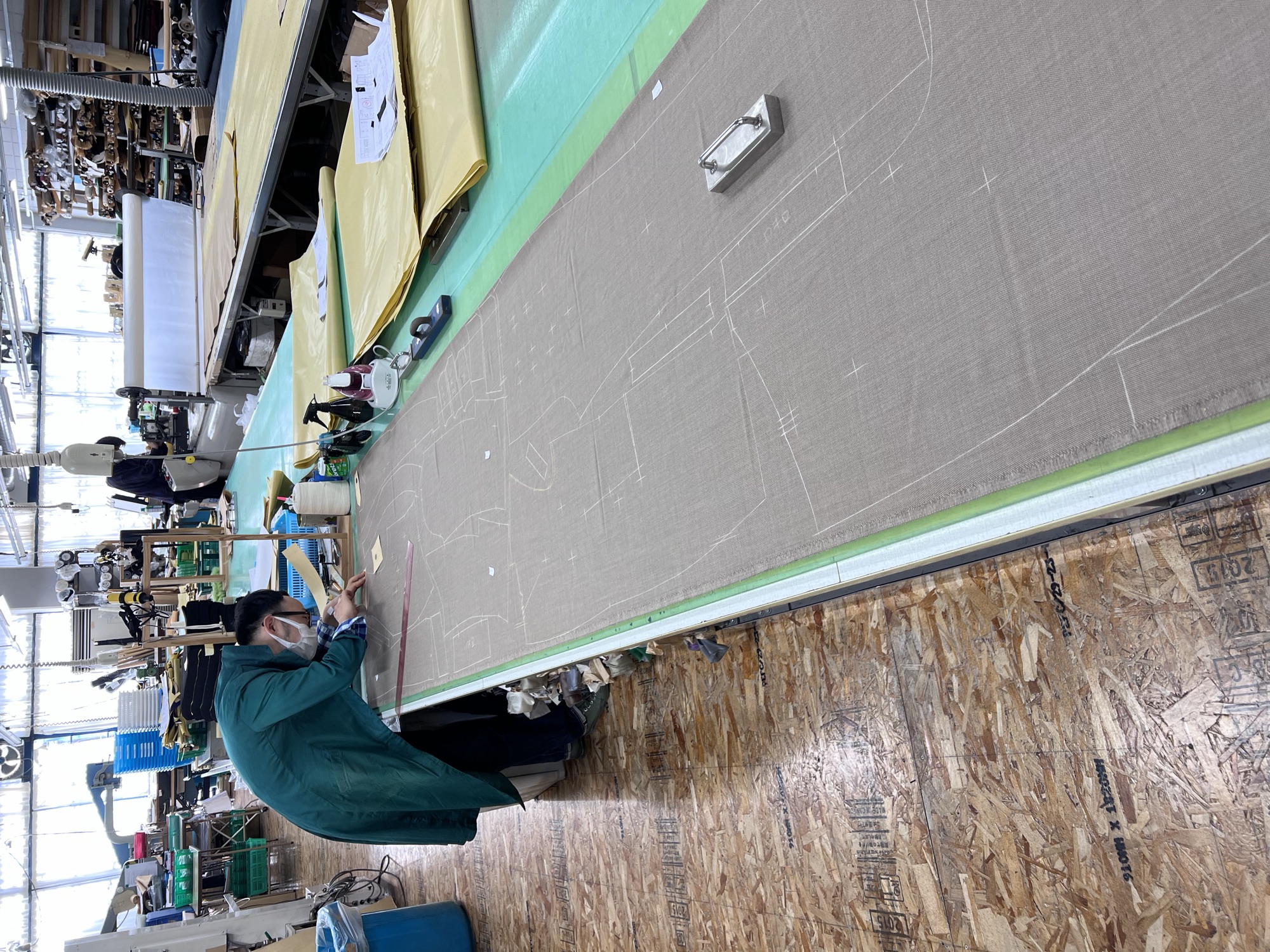 A cutter chalking a jacket layout onto cloth at Five One Factory, Hirakata